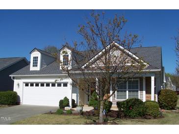 Charming home with a two-car garage and a well-maintained front yard with trees and shrubs at 1215 Agile Dr, Knightdale, NC 27545