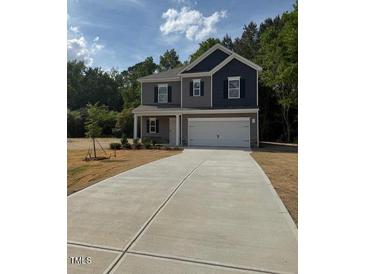 Charming two-story home featuring a gray and navy blue color scheme with a spacious two car garage at 136 Baneberry Pl, Broadway, NC 27505