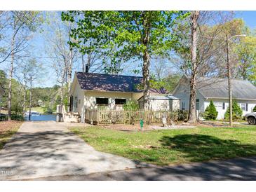 Charming lakeside home featuring a well-maintained lawn and a boat ramp for easy water access at 150 Big Horn Cv, Louisburg, NC 27549