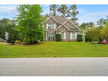 Charming two-story brick home with a well-manicured lawn and lush landscaping at 201 Blue Heron Dr, Youngsville, NC 27596