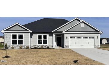 Charming single-story home featuring gray siding, stone accents, and a two-car garage at 21 Shoreline Dr, Lillington, NC 27546