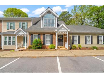 Charming townhome featuring a brick facade, a gray roof, a well-maintained lawn and black shutters at 2102 Trailridge Ct, Raleigh, NC 27603