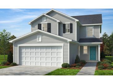 Charming two-story home with a two-car garage, manicured lawn and a welcoming blue front door at 2640 Pivot Ridge Dr, Raleigh, NC 27616