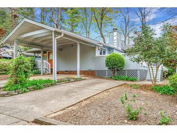 Charming home with a covered driveway and landscaped front yard and gray wood siding at 2916 Rue Sans Famille, Raleigh, NC 27607