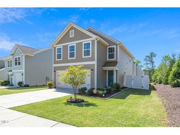Charming two-story home features a well-manicured lawn and a two-car garage at 317 City Center Ln, Wendell, NC 27591