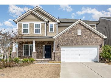 Charming two-story home with a brick and siding exterior, featuring a two-car garage and well-maintained landscaping at 3360 Bordwell Ridge Dr, New Hill, NC 27562