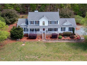 Charming two-story home with a covered front porch, black shutters, and lush landscaping at 3787 Pleasant Hill Church, Siler City, NC 27344