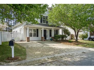 Charming home featuring a covered porch, black shutters and a well-maintained landscaped yard at 4414 Nightfall Ct, Durham, NC 27713