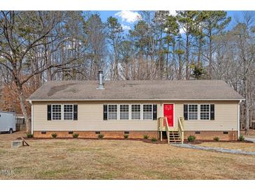 Charming single-story home features a red front door and a well-maintained front yard at 4720 Brigadoon Dr, Durham, NC 27705