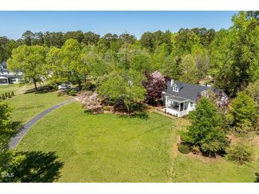 Charming home on a lush green lawn with mature trees, offering privacy and a serene setting at 5212 Theys Rd, Raleigh, NC 27606