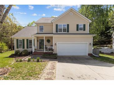 Charming two-story home with green shutters, a two-car garage, and a well-manicured front yard at 703 Midsummer Ln, Apex, NC 27502