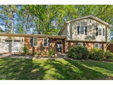 Charming two-story home with a well-maintained lawn, brick facade, and lush landscaping at 730 N Harrison Ave, Cary, NC 27513