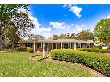 Charming brick home with manicured lawn, trimmed hedges, and classic architectural details under a sunny sky at 806 S Second St, Smithfield, NC 27577
