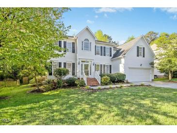 Traditional two-story home featuring black shutters, a well-manicured lawn, and a brick front stairway at 102 Cockleshell Ct, Cary, NC 27513
