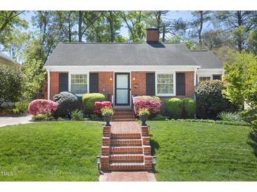 Charming brick home featuring a manicured lawn, brick walkway and lush landscaping at 1109 Huntington Ave, Durham, NC 27707