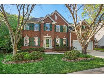 Charming two-story brick home with a well-manicured lawn and lush landscaping at 1216 Caribou Xing, Durham, NC 27713