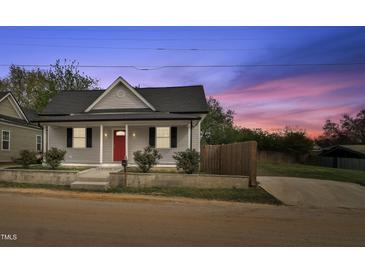 Charming single-story home featuring a red front door, grey siding, and well-maintained landscaping at 1284 Railroad St, Henderson, NC 27536