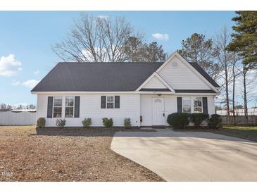 Charming single-story home with a well-maintained yard and a long concrete driveway at 1432 E Stonemason Dr, Fuquay Varina, NC 27526