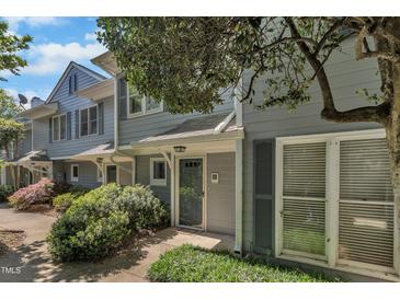 Charming townhome exterior with gray siding, lush landscaping, and inviting front entrance at 1442 Barton Place Dr, Raleigh, NC 27608