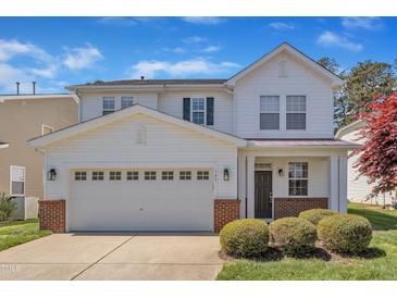 Charming two-story home with a well-manicured front lawn and a two-car garage on a sunny day at 145 Ryder Cup Cir, Raleigh, NC 27603