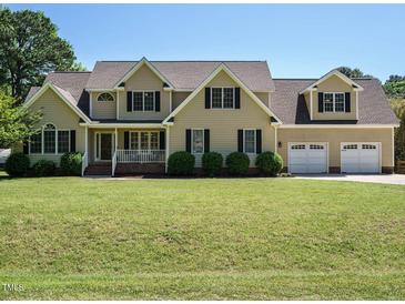 Charming home featuring a manicured lawn, black shutters and a three car garage at 2213 Ravens Creek Ct, Raleigh, NC 27603