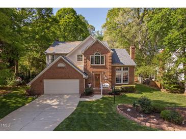 Charming two-story brick home with a well-manicured lawn and an attached two-car garage at 2221 Dungiven Ct, Garner, NC 27529