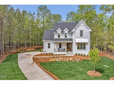 Charming home featuring a well-manicured lawn and a long, winding driveway leading up to the inviting front porch at 30 Mist Wood Ct, Pittsboro, NC 27312