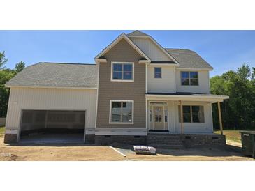 Charming two-story home featuring a classic design, attached garage, and inviting front porch at 317 Hampshire Court, Four Oaks, NC 27524