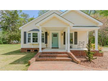 Charming home featuring a welcoming front porch with a bright, light-blue front door at 322 W Hill N Ave, Hillsborough, NC 27278