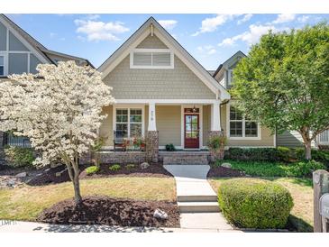 Charming home featuring a craftsman-style front porch, neat landscaping, and a blossoming tree at 379 Tobacco Farm Way, Chapel Hill, NC 27516