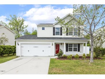 Charming two-story home featuring a two-car garage, red front door, and a well-manicured lawn with landscaping at 4817 Quarryman Rd, Raleigh, NC 27610
