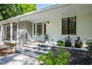 Inviting front entrance featuring a light blue door, stone steps, and elegant landscaping at 4902 Brookhaven Dr, Raleigh, NC 27612