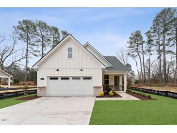 Charming, modern farmhouse style home with white siding, two-car garage, and well-manicured front lawn at 502 Gainer Dr # 2, Raleigh, NC 27610