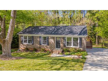 Charming brick home with black shutters, mature trees, and a well-maintained lawn at 6105 Bellow St, Raleigh, NC 27609