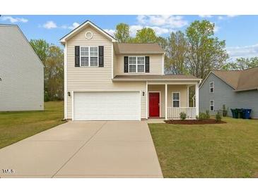 Charming two-story home featuring a well-maintained lawn, a two-car garage, and a welcoming front porch at 6863 Paint Rock Ln, Raleigh, NC 27610