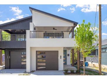 Modern two-story home with a sleek design, balcony, and a two-car garage showcasing contemporary curb appeal at 730 Hopkins St, Durham, NC 27701