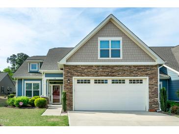 Charming two-story home featuring a stone facade, two-car garage, and manicured lawn at 74 Revelstoke Dr, Garner, NC 27529