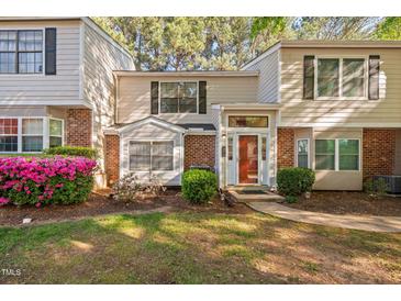Charming townhome with a brick facade, well-manicured landscaping, and a welcoming front entrance at 7707 Falcon Rest Cir, Raleigh, NC 27615