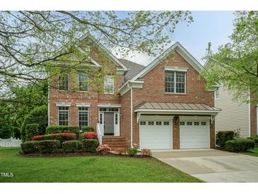 Charming brick two-story home featuring an attached two-car garage and manicured landscaping at 9225 Palm Bay Cir, Raleigh, NC 27617
