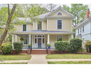 Charming two-story home featuring a welcoming front porch and well-manicured landscaping at 1005 W Lenoir St, Raleigh, NC 27603