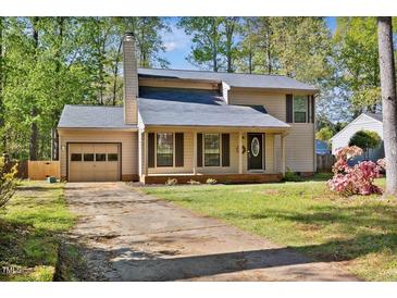 Charming two-story home with a neutral exterior, attached garage, and mature trees at 1517 Laughridge Dr, Cary, NC 27511