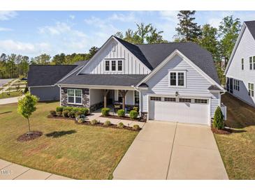 Charming home features a two-car garage, stone accents, covered porch and manicured landscaping at 158 Sea Foam Dr, Raleigh, NC 27610