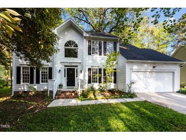 Charming two-story white home featuring a manicured lawn and two-car garage at 3514 Shady Creek Dr, Durham, NC 27713