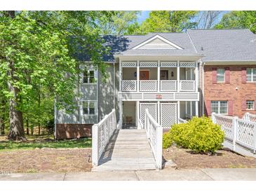 Charming condo featuring a covered entryway with white railing and a well-maintained yard at 407 Gooseneck Dr # A2, Cary, NC 27513