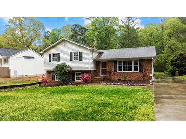 Charming two-story home featuring a brick and vinyl facade with a well-maintained front yard and mature landscaping at 505 Forest Rd, Oxford, NC 27565