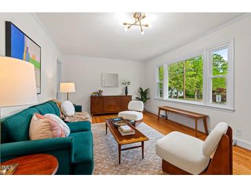 Bright living room with hardwood floors, stylish furniture, and a large window offering a view of the outdoors at 513 Hugo St, Durham, NC 27704