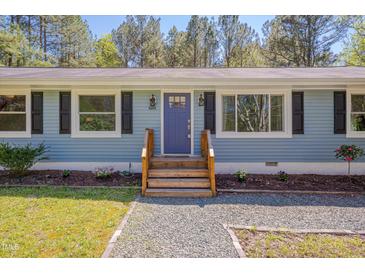Charming single-story home with light blue siding, black shutters, and a neatly landscaped front yard at 5604 Bobcat Rd, Chapel Hill, NC 27516