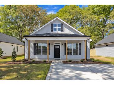 Charming single-story home with a welcoming front porch and black shutters and door at 619 Ray St, Selma, NC 27576
