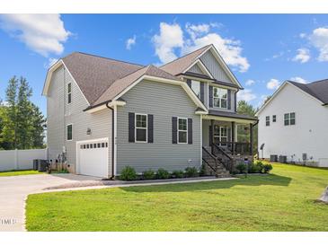 Charming two-story home with attached garage, manicured lawn, and inviting covered porch at 810 Mulberry Rd, Spring Hope, NC 27882