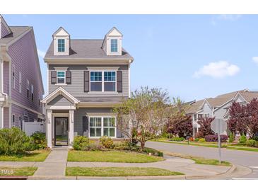 Charming two-story home features dormer windows, gray siding, and a well-manicured front yard with mature landscaping at 900 Ambergate Sta, Apex, NC 27502